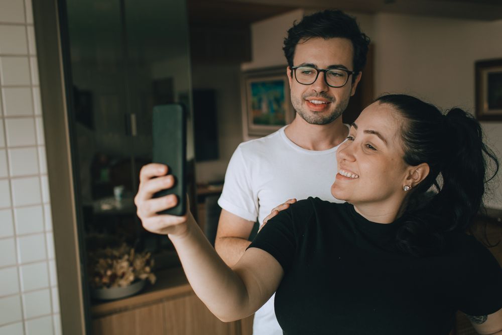 Una pareja se hace un selfie en casa.
